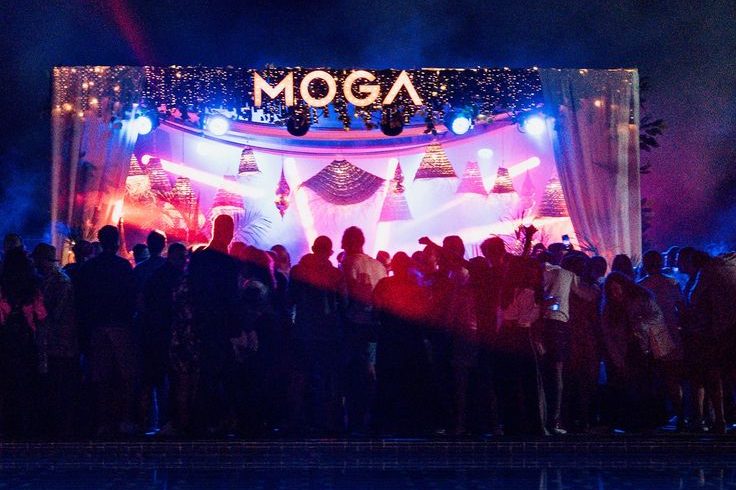 Público bailando frente al escenario iluminado del MOGA de noche en Essaouira